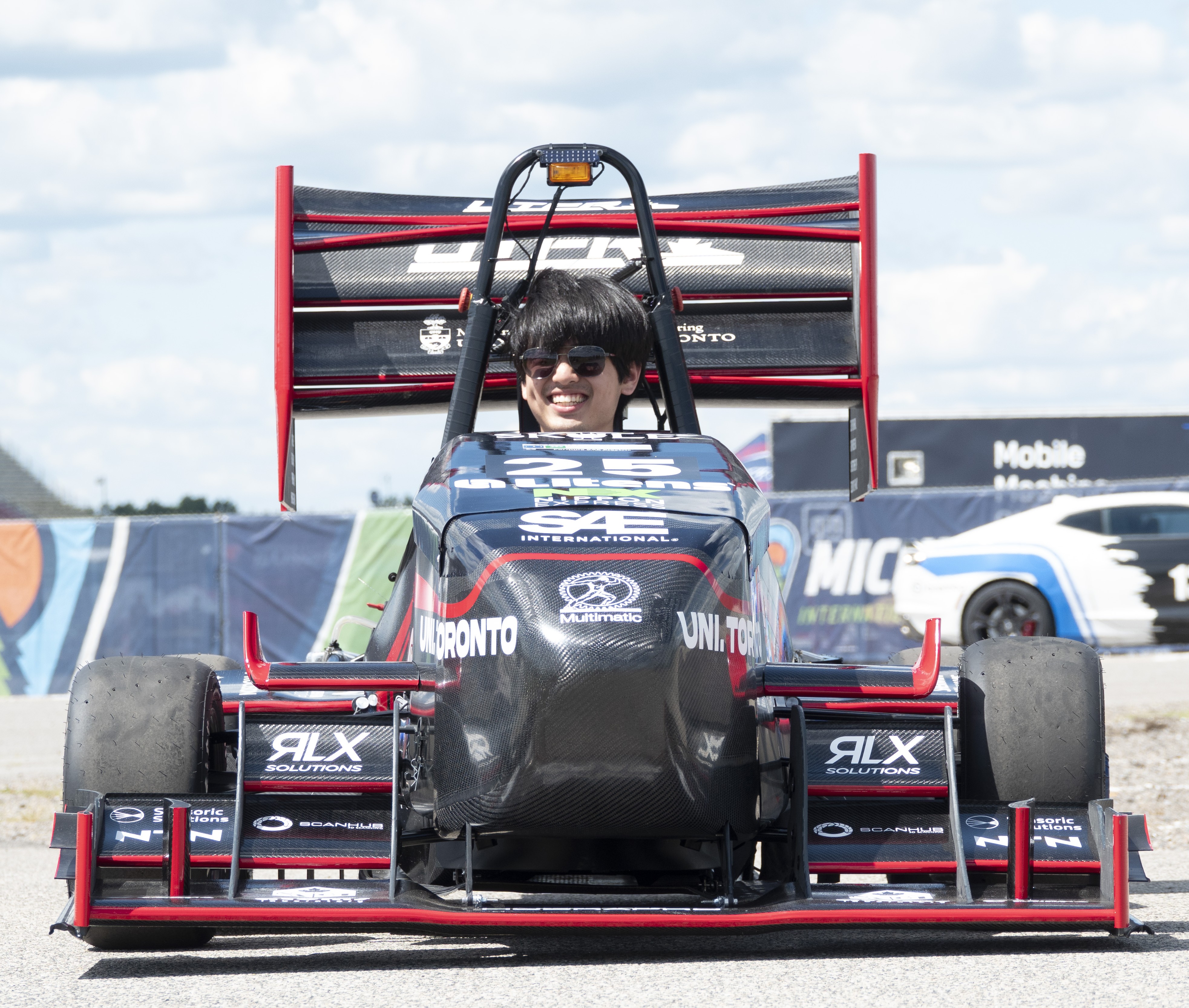 Allan Zhou in front of Red Bull Formula 1 car